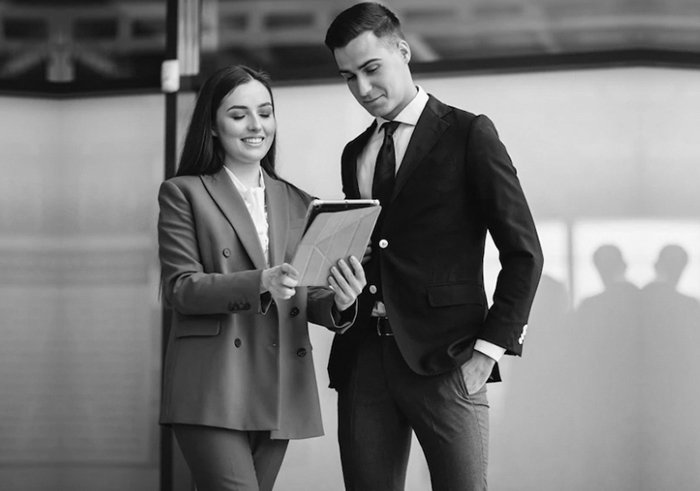 Two banking professionals reviewing a tablet